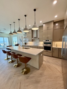 The kitchen is fully equipped and offers additional seating at the bar