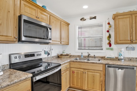The updated kitchen features stainless appliances and granite counters