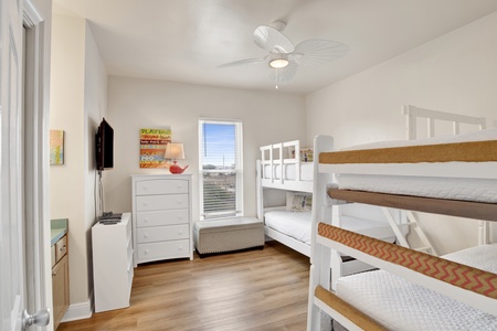 Bedroom 2 has two sets of twin bunks, TV and a vanity with sink