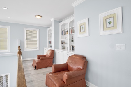 The 2nd floor landing has comfy arm chairs and a stocked bookshelf