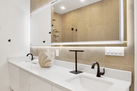 The master bathroom offers double vanities and LED mirrors