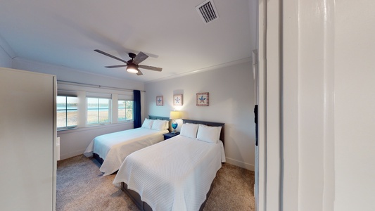 Bedroom 5 is on the 2nd floor and sleeps 4 in 2 queen beds, has a ceiling fan, TV and an attached half bathroom