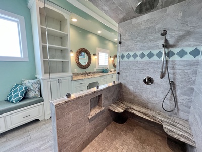 Featuring a walk-in tile shower with bench seating
