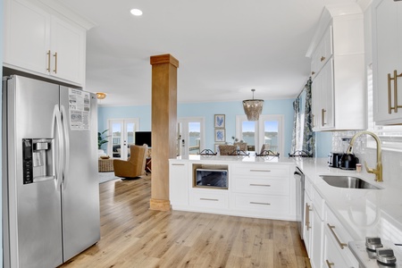Roomy kitchen with stone countertops, tile backsplash and stainless appliances