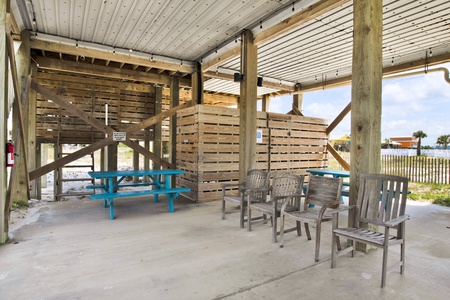 The carport offers 2 picnic tables, propane grill, outdoor enclosed shower and storage for beach supplies