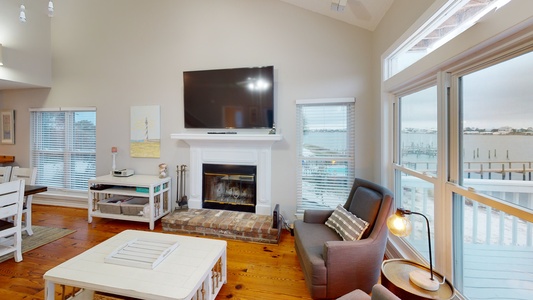 The living area boasts a mounted TV, fireplace and access to the 2nd floor deck