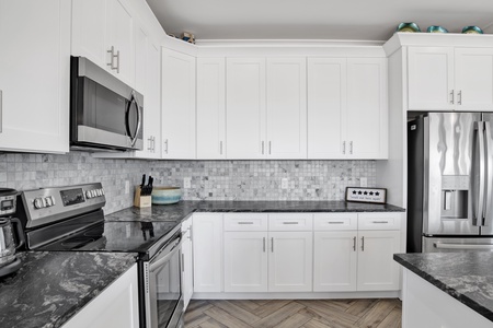 Kitchen has tile backsplash, granite countertops and stainless appliances