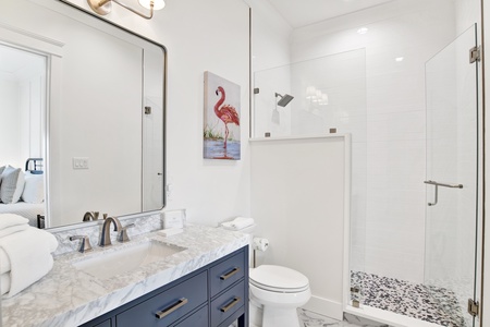 The private bathroom features a walk-in, tile shower
