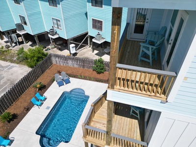 The back decks with seating- the 1st floor deck has stairs down to the pool