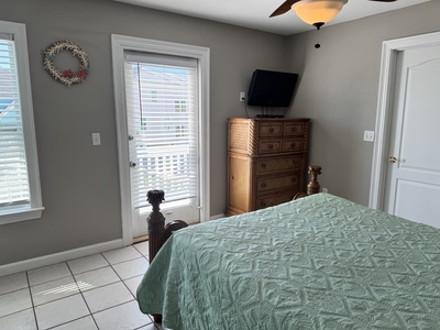 This bedroom has balcony access and a TV