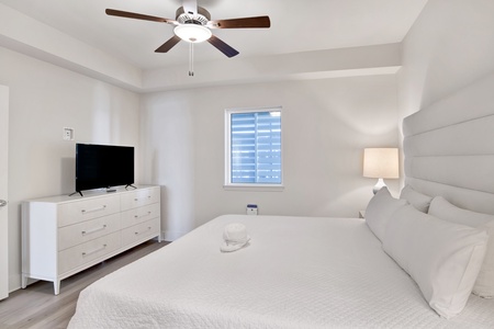 The main bedroom comes with a ceiling fan and a television