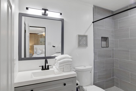 The primary bathroom features a walk-in tile shower