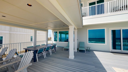 Covered deck next to pool with seating for 8
