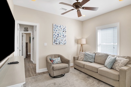 Main floor media room with a large TV and a sofa sleeper