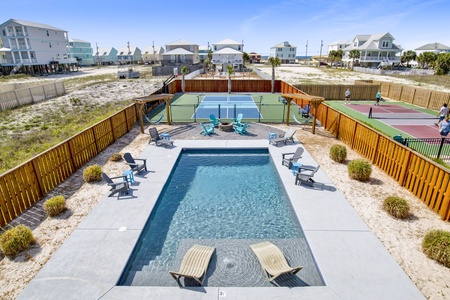 View of the pool, fire pit and pickleball court from the deck