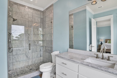 The private bathroom features a walk-in tile shower