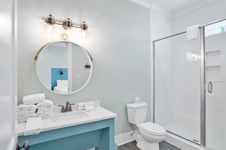 The guest bathroom features a walk-in, tile shower