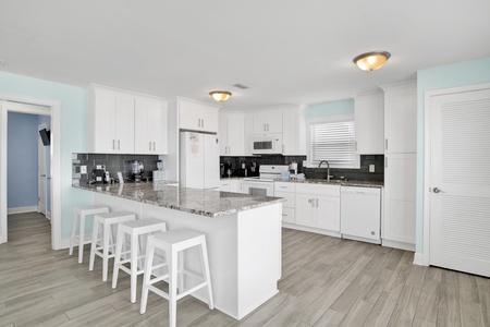 Spacious kitchen with granite countertops, significant counter space, and bar seating for 4