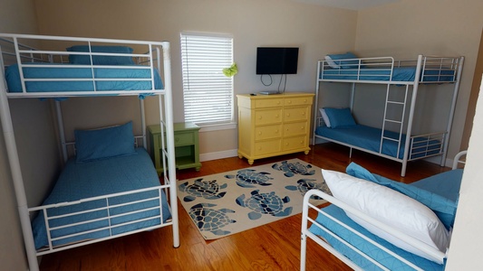 Bedroom 4 is on the 2nd floor and sleeps 5 in 2 twin bunks+1 twin bed and has a TV, balcony access and a private bath