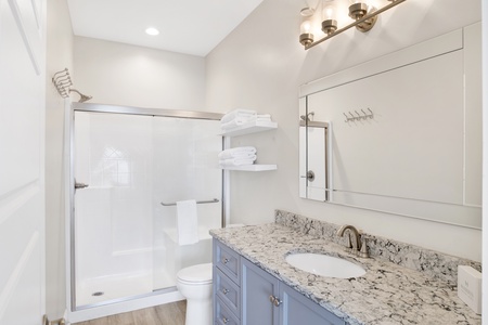 The private bathroom features a walk-in, tile shower