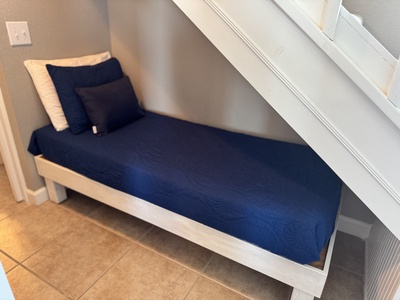 Twin bed in the alcove under the stairs