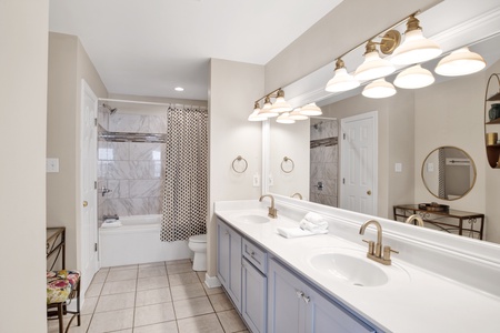 Private master bedroom with a double vanity and a tub/shower combo