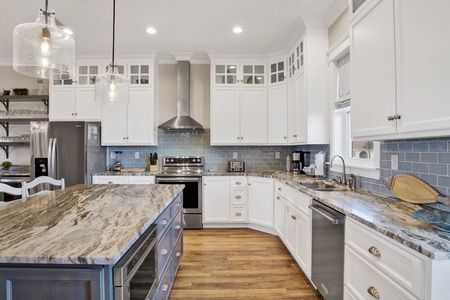 Spacious kitchen with stone counters and stainless appliances