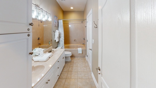 The attached bath to Bedroom 3 also has a hall entrance. This room has a jetted tub/shower combo and a double vanity