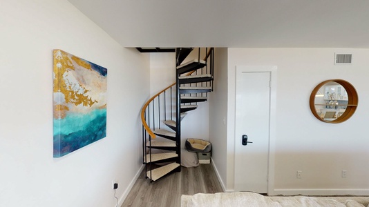 Spiral stairs in the living area leading upstairs to bedroom #3