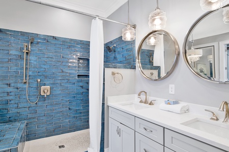 Master bathroom has double vanities and large tile shower