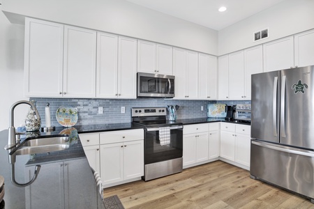 The beautifully updated kitchen has plenty of counter space and stainless appliances