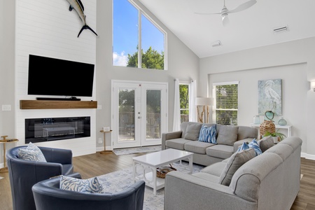 The living room features a TV and balcony access