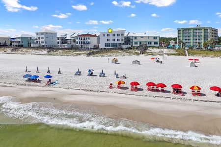 Expansive white sandy beach area in front of the home