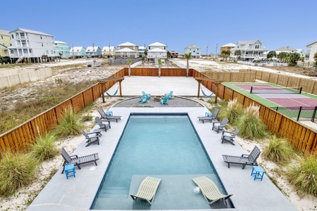 View of the pool, fire pit and pickleball court from the deck