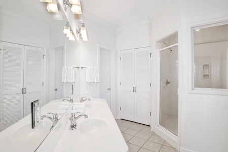 The private bath in bedroom 1 has a double vanity and a walk-in shower