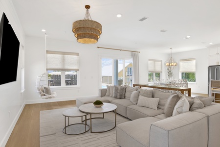 The living room offers a large sectional sofa and TV