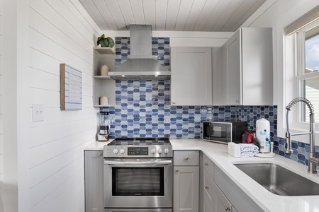 Updated kitchen offers stainless appliances and stone counters