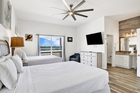 Bedroom #4 has a mounted TV, lagoon views and a ceiling fan