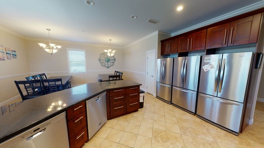 The kitchen features 3 refrigerators, 2 dishwashers, significant counter space, and bar seating