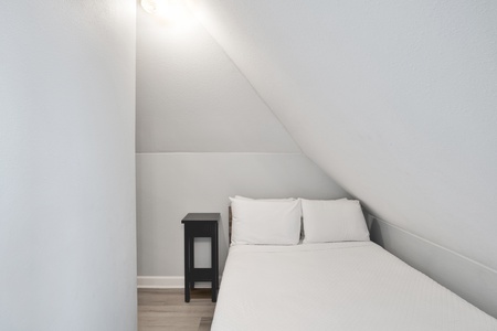 Small sleeping room (#1) on the 3rd floor with a full bed and a sliding barn door