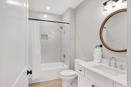 1st floor guest bathroom located in hallway with a tub/shower combo