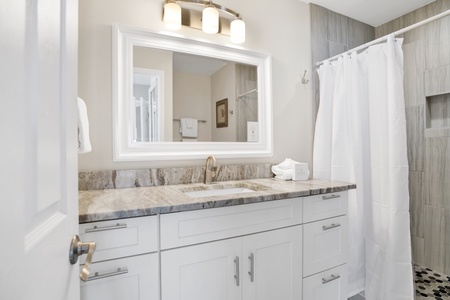 The primary bathroom offers granite counters