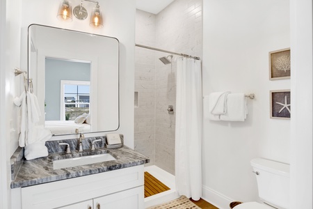 2nd floor guest bathroom located in hall with a tiled walk-in shower