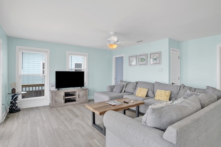 Living area features a large sectional that also doubles as a sofa sleeper for 2, TV, and access to the beach front deck