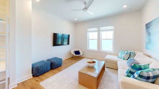 Additional living area on the second floor with a mounted TV