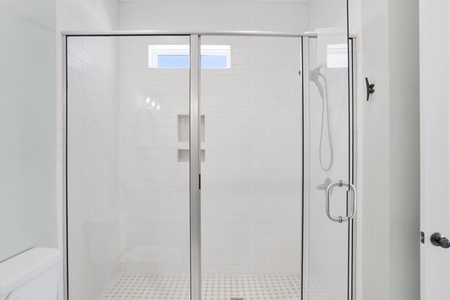 The guest bathroom features a walk-in, tile shower