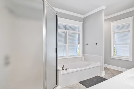 The private bath in Bedroom 5 has a walk-in shower and a soaking tub