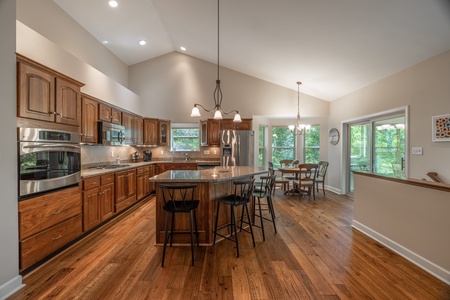 The fully equipped kitchen with stainless steel appliances, granite countertops, and custom cabinetry are a chef's dream