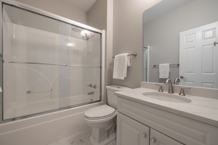 Sleek and pristine full bathroom on the main level