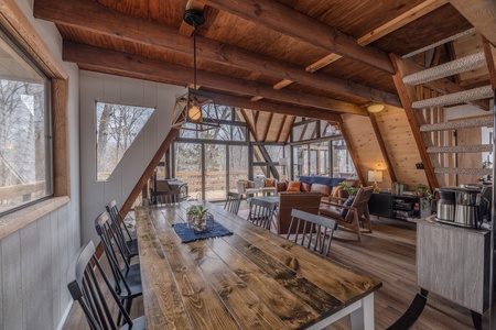 The large dining table that sits eight is placed between the kitchen and living areas surrounded by windows and the beautiful wooded scenes beyond.